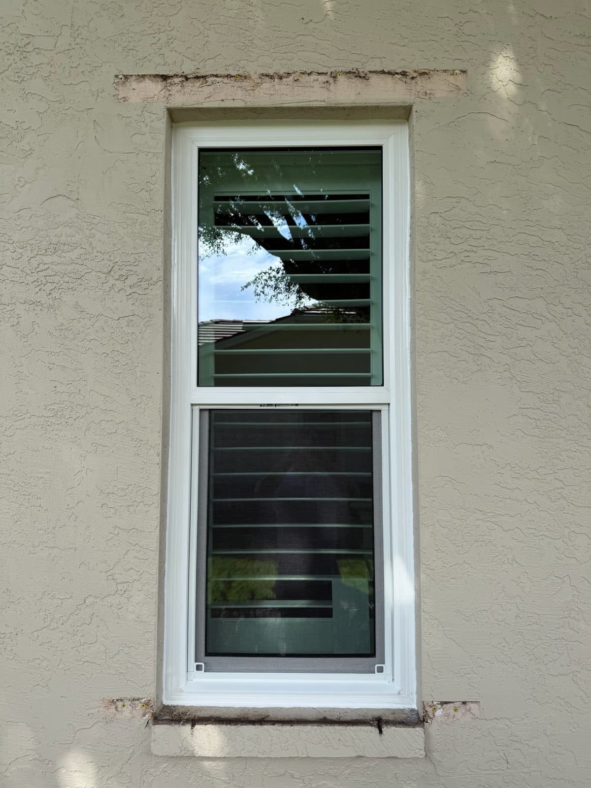 Replacement window with a fresh stucco patch band above the header, Bonita Springs