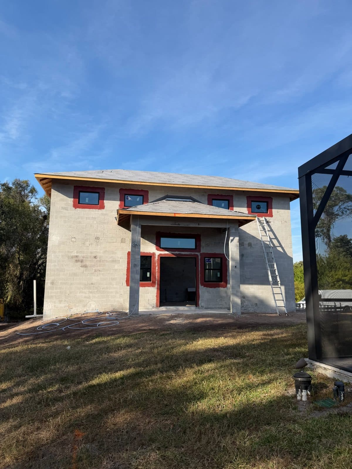 Two-story block home in Parrish with new impact windows and an entry door set in the openings