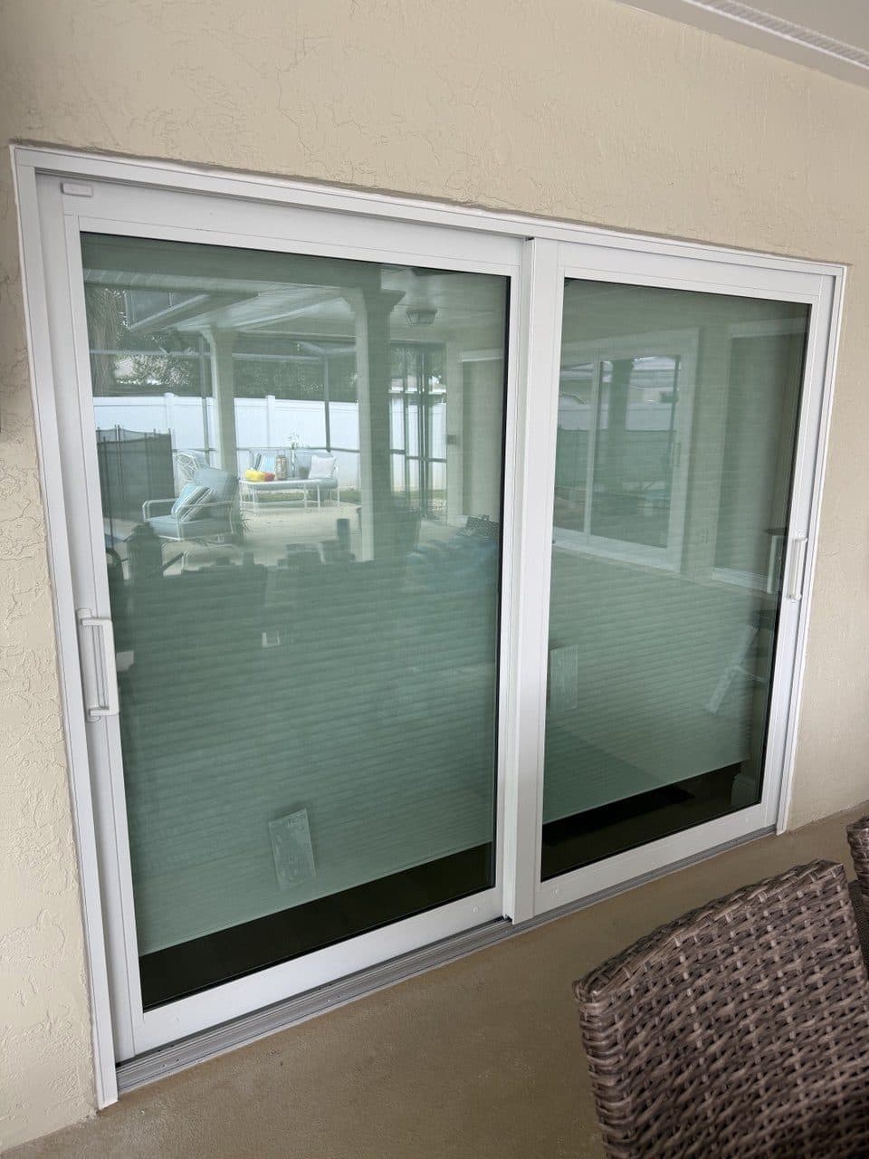 Close view of a new white sliding glass door frame on a pool lanai