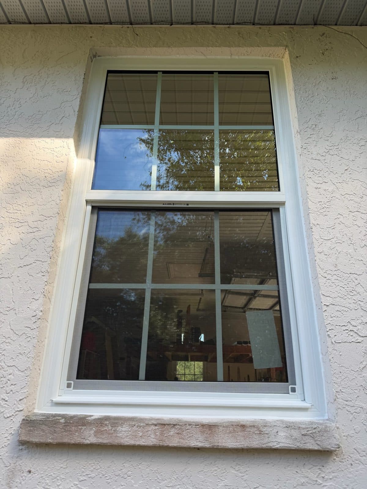 White single-hung window with colonial grids in a stucco wall, Port Charlotte