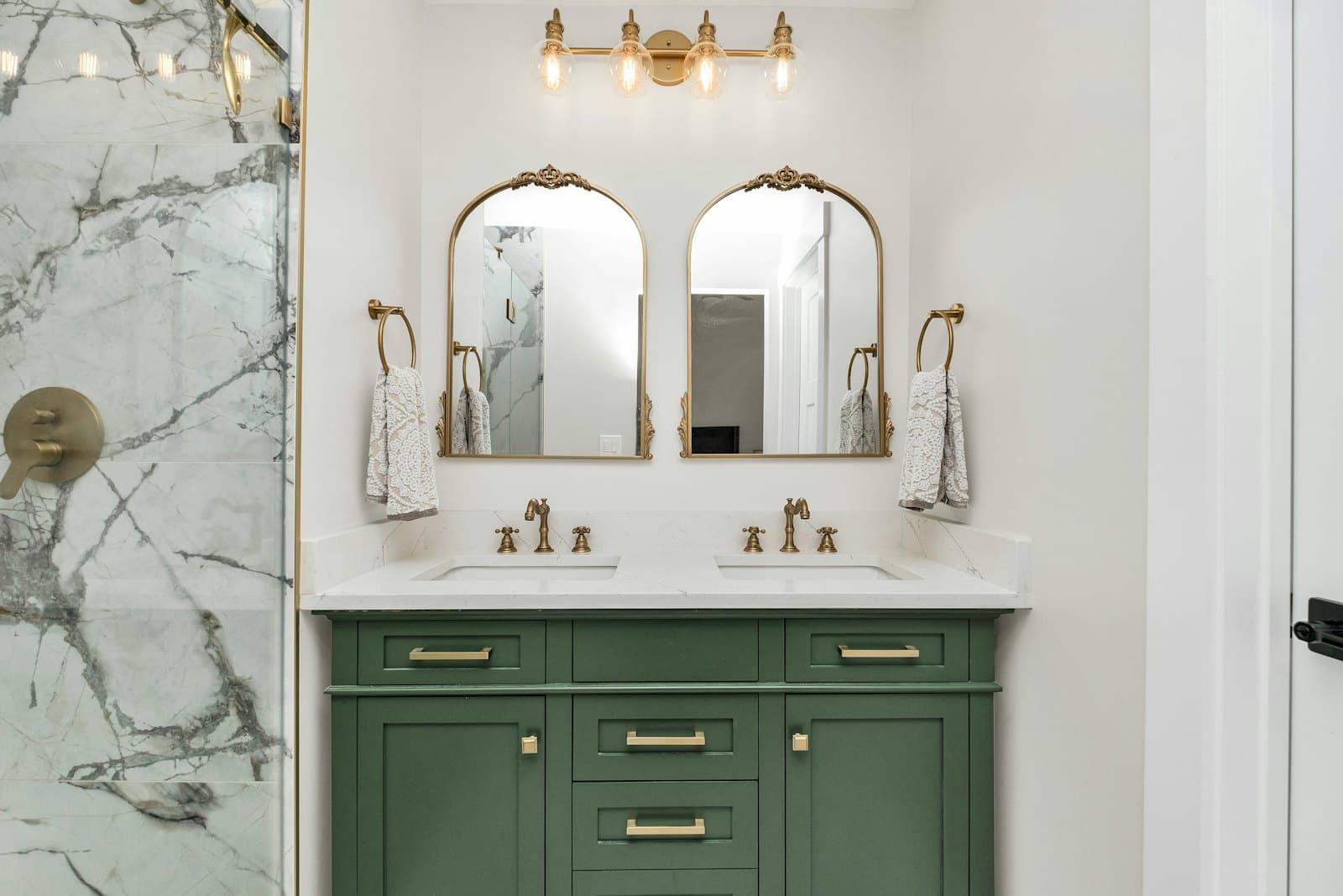 Bathroom with green vanity cabinets and marble countertops