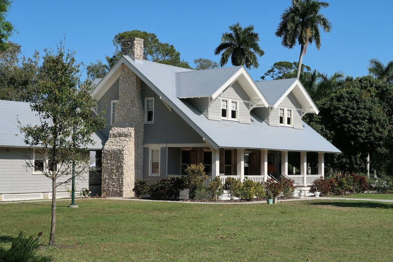 Gray single-family home with a stone chimney and front porch in Fort Myers, Florida