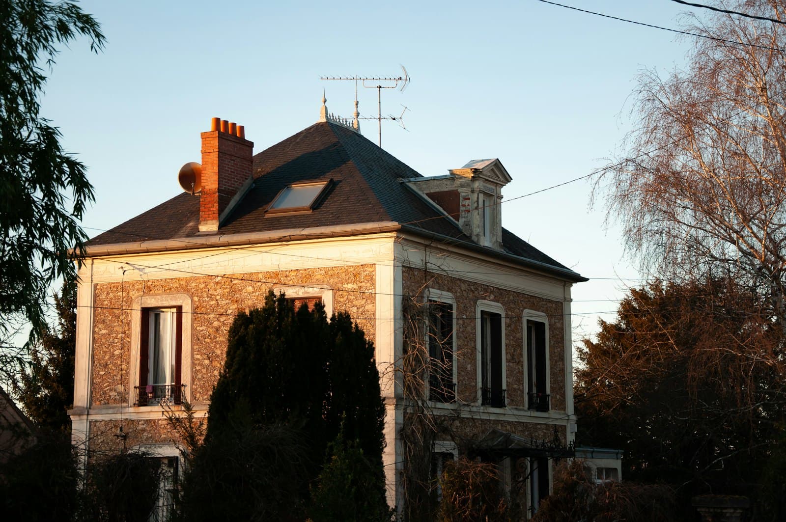 Older brown and white house with dated exterior finishes