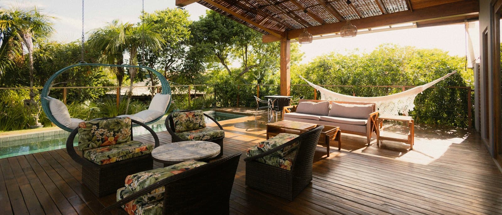 Covered lanai with seating and a hammock overlooking the pool