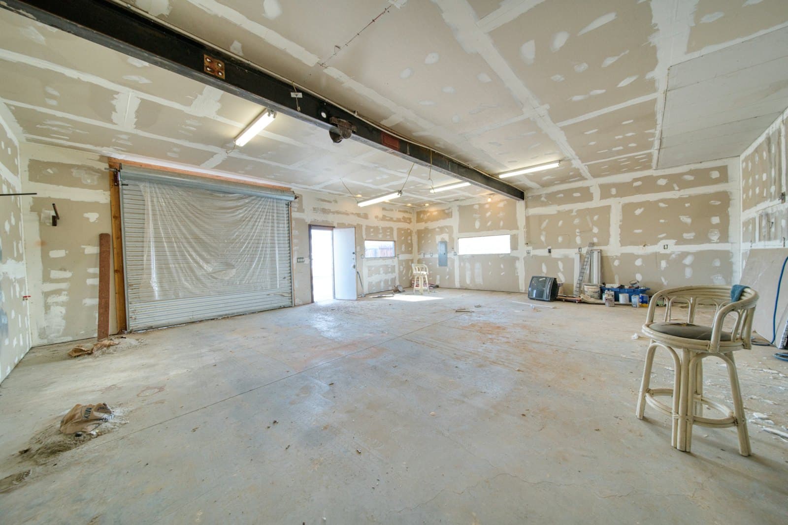 Large interior room with fresh drywall mud and primer during renovation